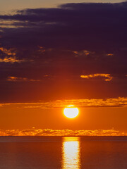 Wall Mural - sunset with large yellow sun under the sea surface