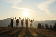 © New Africa - Group of people enjoying sunrise in mountains, back view