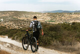Fototapeta  - Professional downhill bicycle rider walking by mountain trail