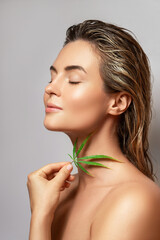 Poster - CBD cosmetics concept. Beautiful woman with a cannabis leaf