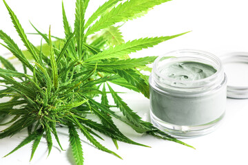 Wall Mural -  Green cannabis plant and jar with a moisturizing cream