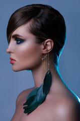 Poster - Model in stylish image with sleek hair covering one eye and feather earring