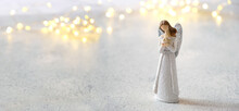 Cute Angel On White Background With Lights Bokeh. Faith In God, Christianity, Memory, Religion Concept. Symbol Of Orthodoxy,  Christmas, Church Holiday. Copy Space
