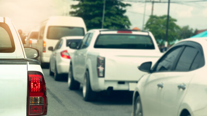 Wall Mural - Rear side of white pick-up car on the asphalt road. With turn brake light. Blurred of several cars were lined up at the intersection. Traffice Traffic congestion on rural roads in Thailand