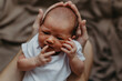 © Ananass - close up portrait of a beautiful baby in the arms of mom in the bedroom in daylight