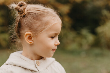 Wall Mural - portrait of a little cute girl walking in the autumn park