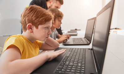 Wall Mural - smart kid studying with laptop in classroom