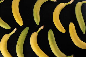 Wall Mural - green and yellow bananas on black background