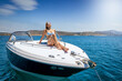 © moofushi - A beautiful, blonde luxury woman in bikini sits on a boat and enjoys the summer sun
