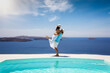 © moofushi - A happy summer holiday couple stands hugging a the swimming pool with view to the mediterranean sea