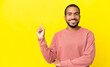 © luismolinero - Young latin man isolated on yellow background happy and pointing up