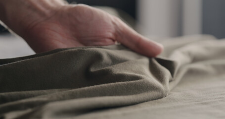 man touching taupe cotton clothes closeup