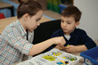 © diignat - Two kids of different age choose parts of robotic electric toys for building robots at robotics school lesson.