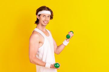 Sticker - Profile side view portrait of attractive cheery sportive guy lifting small dumbbell isolated over bright yellow color background