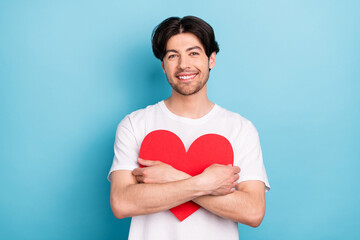 Sticker - Photo of optimistic millennial brunet guy hug heart wear white t-shirt isolated on blue color background