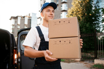 Courier service employee in uniform. The courier brought the delivery of the box to the client.