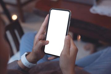 Poster - Cell phone mockup image blank white screen.  Woman hand holding, using mobile phone in coffee shop, close up