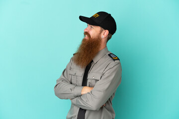 Wall Mural - Redhead security man isolated on white background with arms crossed and happy