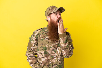 Wall Mural - Military Redhead man over isolated on yellow background yawning and covering wide open mouth with hand