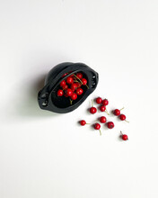 Spilled Red Berries From Small Black Cauldron Isolated On White Background. 
