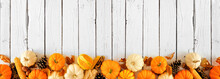 Fall Bottom Border Of Pumpkins, Leaves And Natural Autumn Decor. Top View On A White Wood Banner Background With Copy Space.