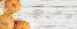 Fall corner border with frosty orange pumpkins on a rustic white wood banner background. Overhead view with copy space.