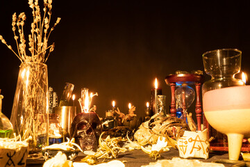 Witchcraft still life with burning candles selective focus on skull. Esoteric gothic and occult witch table for Halloween. Magic objects and ritual arrangement. Shallow depth of field.