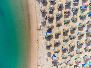 Wall Mural - Top down view of a beach with tourists suntbeds and umbrellas with sand beach and clear blue water in egypt