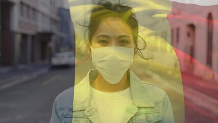 Wall Mural - Animation of flag of belgium waving over woman wearing face mask during covid 19 pandemic