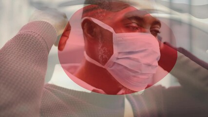 Sticker - Animation of flag of japan waving over man wearing face mask during covid 19 pandemic