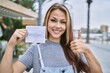 © Krakenimages.com - Young caucasian woman holding covid record card smiling happy and positive, thumb up doing excellent and approval sign