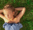 © StasyDolce - beautiful girl relaxing lying on the grass in the garden