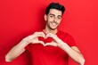 © Krakenimages.com - Young hispanic man wearing casual clothes smiling in love showing heart symbol and shape with hands. romantic concept.