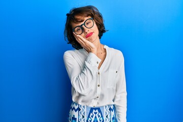 Sticker - Young brunette woman wearing casual clothes and glasses thinking looking tired and bored with depression problems with crossed arms.