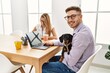 © Krakenimages.com - Two business workers smiling happy working with dog at the office.