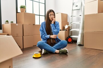 Sticker - Young chinese girl sitting on the floor at new home looking stressed and nervous with hands on mouth biting nails. anxiety problem.