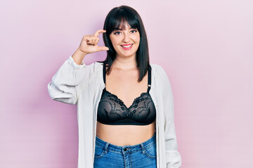 Sticker - Young hispanic woman wearing lingerie smiling and confident gesturing with hand doing small size sign with fingers looking and the camera. measure concept.