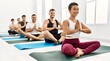 © Krakenimages.com - Group of young hispanic people smiling happy training yoga at sport center.