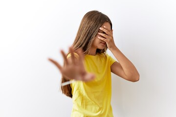 Poster - Young brunette teenager standing together over isolated background covering eyes with hands and doing stop gesture with sad and fear expression. embarrassed and negative concept.