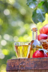 Wall Mural - apple cider or juice in glass and bottle outdoors