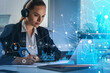 © ImageFlow - Attractive concentrated businesswoman in headphones taking notes in front of laptop, video conference meeting, blue glowing information protection icons. Padlock and digital interface. Cyber security