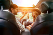 © Valerii Apetroaiei - A young couple are giving five to each other in a new car. A man driving a car with his girlfriend and having fun. Buying and renting a car. Travel, tourism, recreation.