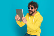 enthusiastic bearded man holding tab and laughing