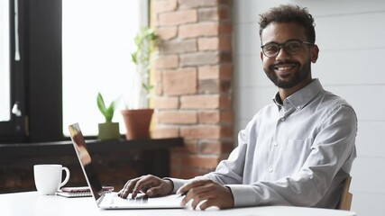 Handsome young man using laptop at home, Businessman or student working online on computer indoors, Freelance, online marketing, distance education, e-learning, work from home concept