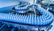 © romaset - Conveyor belt with bottles of drinking water at a modern beverage plant.