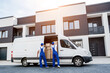 © romaset - Two removal company workers unloading boxes from minibus into new home