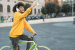 © Alessandro Biascioli - Happy African man taking selfie with mobile smartphone outdoor - Young guy having fun riding with bike in the city - Youth millennial generation lifestyle and technology concept