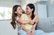 © Kawee - Asian beautiful lesbian women couple combing girlfriends hair in house.