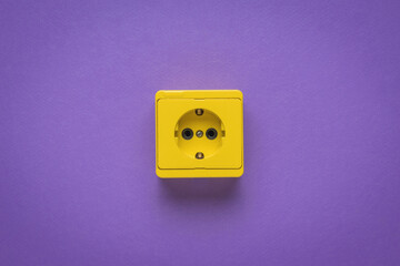 Yellow electrical outlet on a purple background.