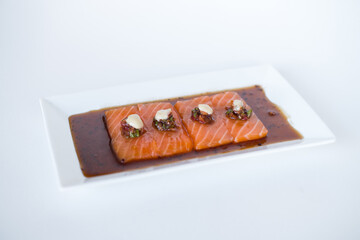 Salmon sashimi with soy sauce on white plate on white background. Isolated on white. Japanese restaurant. Japanese traditional food. Healthy food